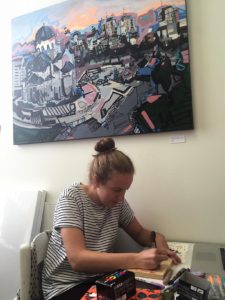 Lizzi Aronhalt painting in her studio on the first floor of Summit Artspace on East Market.