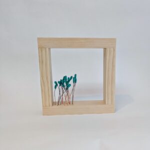 A square, wooden frame with glass beads sitting on top of wires situated in the bottom left corner.