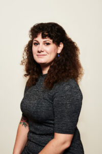 A woman with curly brown shoulder length hair